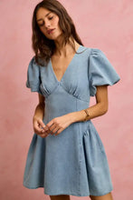 A light blue denim fit and flare mini dress with bubble sleeves and a v neckline in bubble sleeves denim style