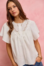 White embroidered cotton gauze blouse with lace trim and flutter sleeves featuring a button-down front design