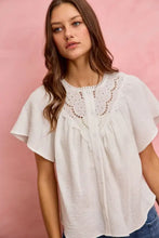 White embroidered cotton gauze blouse with lace trim and soft flowing flutter sleeves for a lightweight look