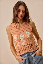 A peach-colored sleeveless so me crochet knitted lace sweater tank top with lace pattern and scalloped hem
