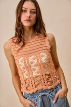 A peach-colored sleeveless crochet knitted lace sweater tank top with intricate lace patterns and scalloped hem