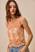 A peach-colored crochet knitted lace sleeveless top with scalloped edges in so me lace sweater tank design