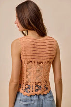 A peach-colored sleeveless crochet knitted lace sweater tank top with intricate lace detailing and scalloped hem