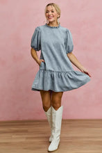 Light blue denim dress with puffed sleeves and ruffled hem in a light wash denim short sleeves mini tiered style