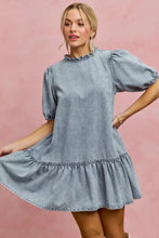 A light wash denim dress with puffed sleeves and ruffled hem in a SO ME denim short sleeves mini tiered style