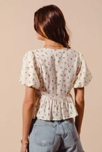 A delicate off-white ditsy floral print gauze blouse with puffed sleeves and peplum hem from SO ME