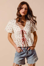 Off-white ditsy floral print gauze blouse with short flutter sleeves and red tie-front v-neckline by so me