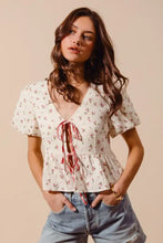 Off-white ditsy floral print gauze blouse with flutter sleeves and v-neck tied with pink ribbons, so me collection