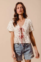 White gauze blouse with red ditsy floral print and a tied bow front from so me ditsy floral print collection