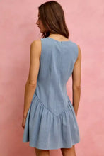 Back view of a light blue denim mini dress with a fitted back and flared skirt from so me fit and flare collection
