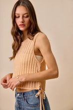 Beige low gauge pointelle sweater tank top featuring ribbed knit and side tie details in a sleeveless crop style