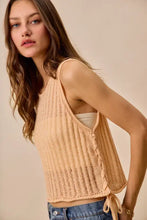 Beige low gauge pointelle sweater tank top with ribbed knit texture and side tie details for lightweight layering