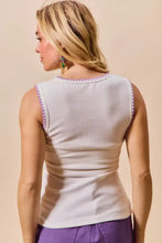A white sleeveless mardi gras tank top with purple contrast blanket stitch trim along neckline and armholes