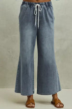 Light-wash denim flare jeans with mid rise elastic waist and white drawstring cord in SO ME Mid Rise Elastic Waist Flare Denim Jeans