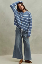 Blue and white striped long-sleeved knit cardigan paired with flare jeans featuring mid rise elastic waist design