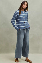 Blue and white striped fuzzy knit cardigan with round neckline paired with so me mid rise elastic waist flare jeans