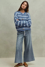 A cozy blue and white striped knit cardigan with fuzzy fabric and gold buttons paired with so me mid rise elastic waist flare jeans