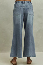 Back view of light-wash mid rise elastic waist flare jeans with two back pockets in denim material