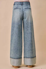 Back view of light-wash mid rise plated wide-leg denim jean with rolled cuffs and back pockets