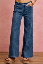 Blue denim jeans with mid rise stretch fit, wide-leg straight cut, high-rise waist, and frayed hems in stretch denim