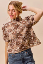 A brown and cream texture floral mesh cropped top with short puffed sleeves and back button closure