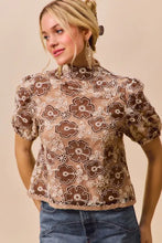 A delicate beige lace so me texture floral mesh top with brown embroidery and puffed short sleeves with back button closure