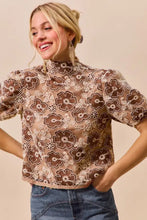 A brown and cream texture floral mesh top with puffed sleeves and back button closure