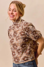 A brown and cream texture floral mesh top with puff sleeves and back button closure for elegant wear