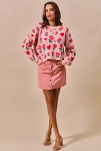 Pink sweater with red roses and hearts embroidered paired with SO ME vintage wash scallop edge denim mini skirt