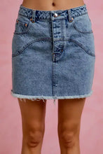 A mid-rise washed denim mini skirt in light blue with floral contrast pockets and a frayed hem