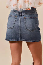 Back view of so me washed denim mini skirt in faded blue with classic pockets and mid-waisted design