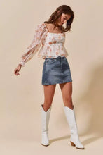 White leather cowboy boots with block heel paired with washed denim mini skirt with pockets for casual wear