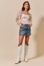 White cowboy boots with embroidered detailing paired with so me washed denim mini skirt with pockets and low block heel