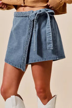 Light-wash denim skort with wrap braided trimmed design and braided belt tied at the waist by so me