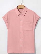 A soft pink solid color cuffed short sleeve shirt with subtle textured fabric and a single chest pocket