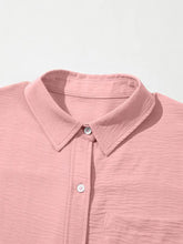 A soft pink textured cotton cuffed short sleeve button-up shirt with classic collar and white buttons
