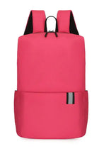 Solid pink nylon backpack bag with black straps and reflective stripe