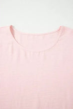 A soft pink lightweight cotton short sleeve blouse with a ruffle trim and simple round neckline