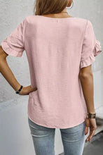 A soft pink textured cotton short sleeve blouse with ruffle trim and a relaxed fit for casual wear
