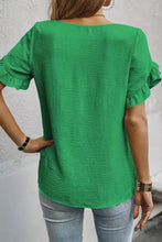 A vibrant green short sleeve blouse with ruffle trim cuffs and a relaxed fit perfect for casual wear