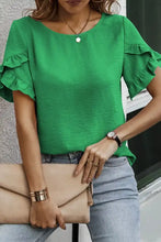 A vibrant green solid color short sleeve blouse with ruffle trim and round neckline perfect for casual wear