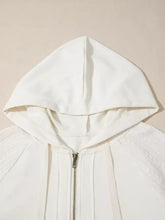 White hooded zip-up jacket with metallic zipper and slightly stretchy textured fabric in solid color patchwork design