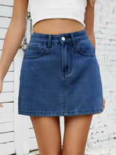A mid-waisted mini denim skirt in medium blue wash with front pockets and button closure solid mini denim skirt