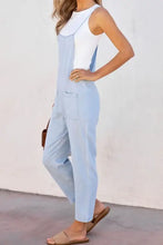 Light blue spaghetti strap denim overalls with white tank top