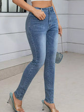 Light-wash high waist skinny jeans with sparkling rhinestone embellishments and slim fit design