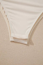 Cream-colored ribbed fabric bikini bottom with subtle textured edge paired with sequin long sleeve bodysuit