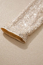 A sparkling sequin long sleeve bodysuit featuring a shimmering silver sequined sleeve with beige lining