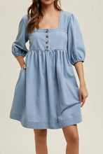 Light blue denim dress with puffed half sleeves and square neck half design featuring brown buttons down front machine wash cold