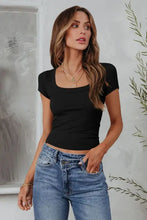Woman modeling black square neck short sleeve tee with blue jeans