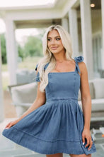 Blue denim dress with square neck tie and flared skirt featuring neck tie shoulder details in denim material